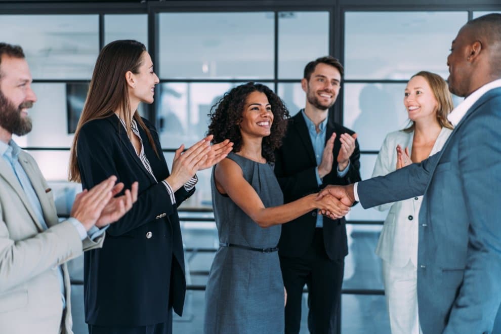 Business Professionals Shaking Hands in a Office, Symbolizing Partnership at PEO Canada