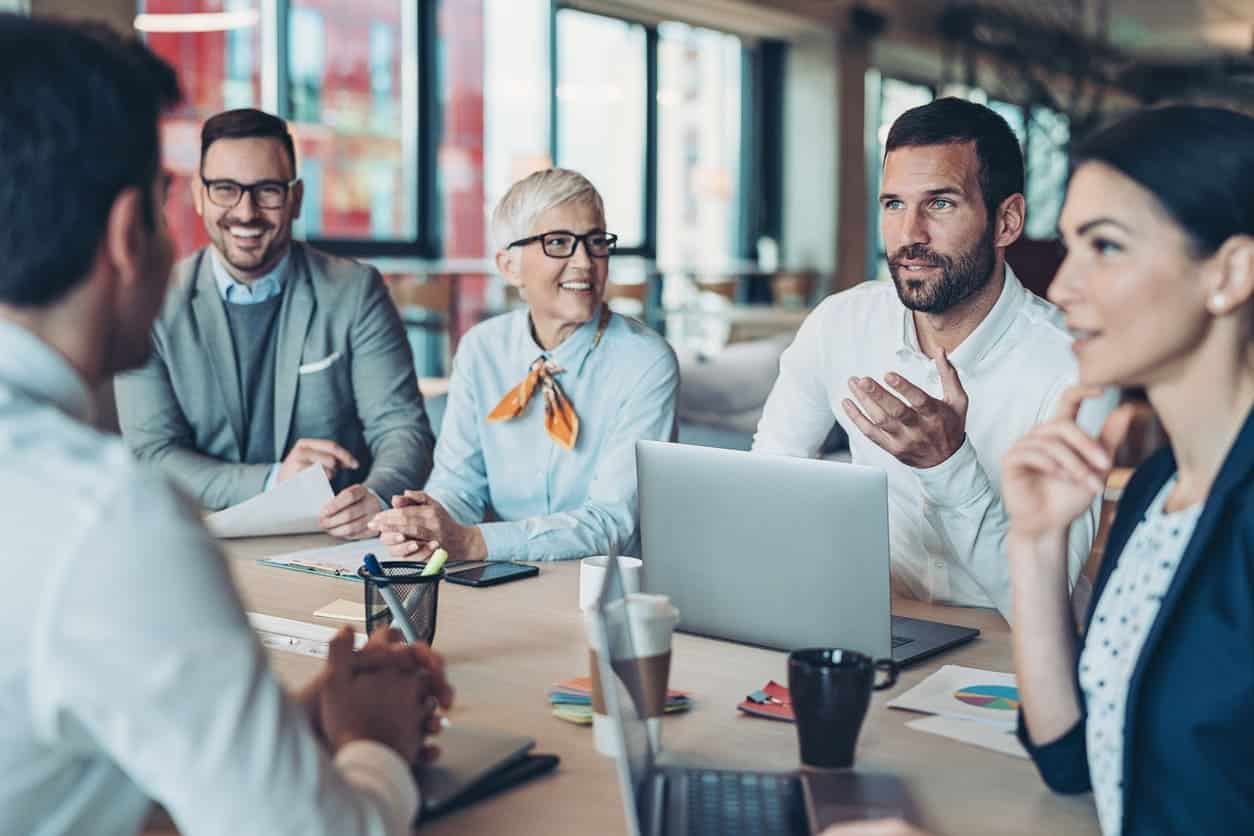 A group of people discussing in a meeting at their office in North America