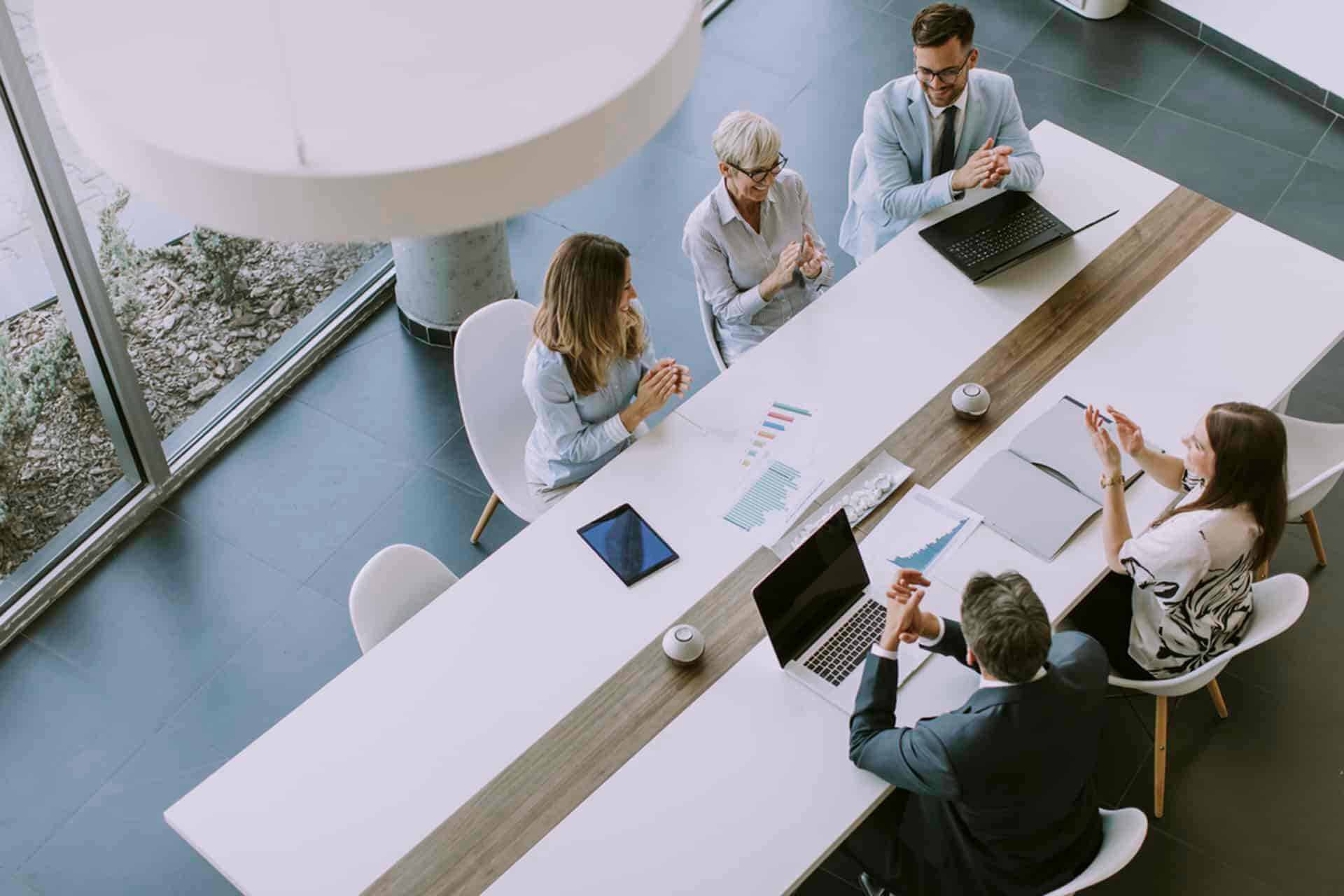 The image is of an office meeting, happening at PEO Canada in North America